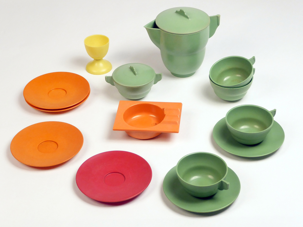 13 kunststoffen afgekeurde poefpersmonsters in diverse kleuren, gemaakt op de Veendammer Perserij tussen 1950 - 1960. Deze proefpersen werden gemaakt om te kijken of de kleur, zuiverheid en samenstelling van de poeders een goed resultaat gaven. Ze zijn gemaakt op het lab van de Veendammer Perserij. alles in de vorm van : 2 groene schotels, 3 oranje schotels, 1 rode schotel, een groene melkkan met deksel, 3 groene kopjes, 1 groen suikerpotje met 2 oren en deksel, een oranje asbak met overhangende zijkanten